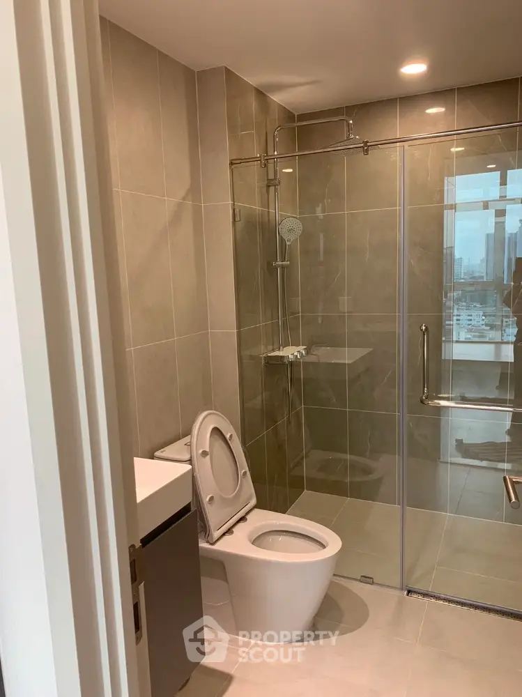 Modern bathroom with glass shower and city view