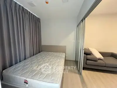 Modern bedroom with sliding glass doors and cozy sofa in a stylish apartment.
