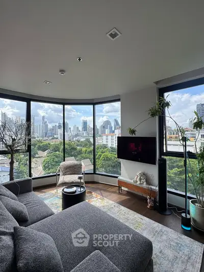 Luxurious living room with panoramic city views and modern decor in high-rise apartment.