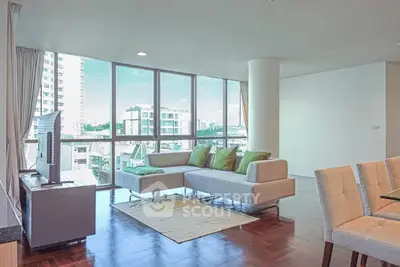 Spacious modern living room with large windows and stylish furniture in a high-rise apartment.