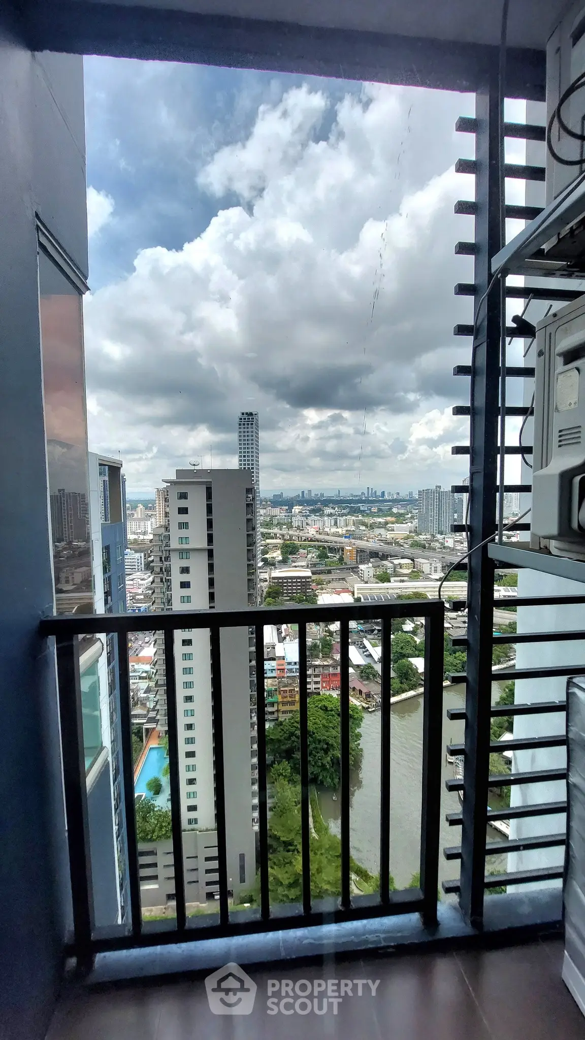 Stunning high-rise balcony view overlooking cityscape and river, perfect for urban living enthusiasts.