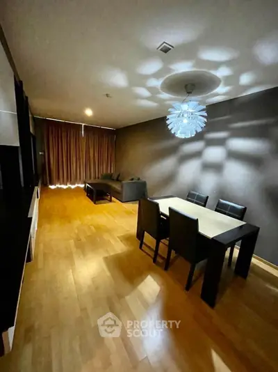 Spacious living room with modern lighting and wooden flooring, perfect for entertaining guests.