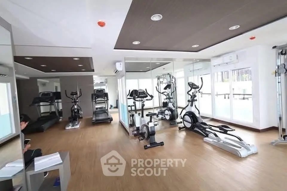 Modern gym with state-of-the-art fitness equipment and mirrored walls in a luxury residential building.