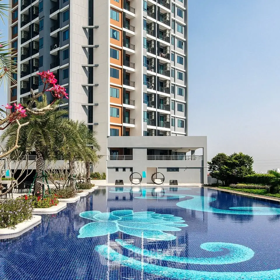 Luxurious high-rise building with stunning pool and landscaped surroundings.