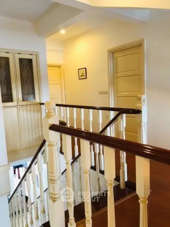 Elegant staircase with wooden railing in a bright, spacious home interior
