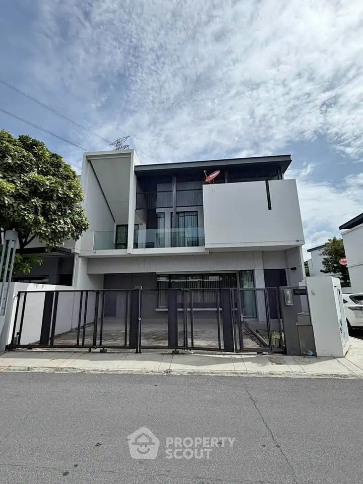 Modern two-story house with sleek design and gated driveway, perfect for contemporary living.