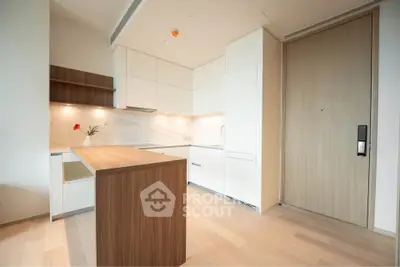 Modern kitchen with sleek cabinetry and wooden island in a stylish apartment.