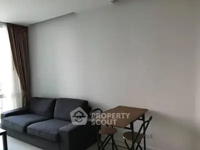 Modern living room with cozy sofa and compact dining area in a stylish apartment.