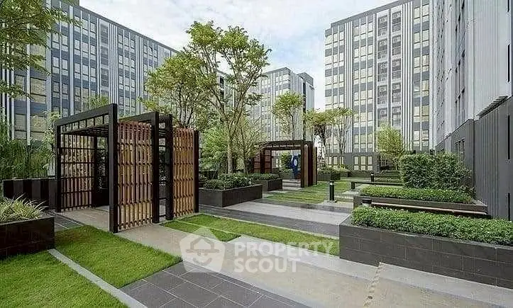 Modern apartment complex with landscaped garden and seating areas