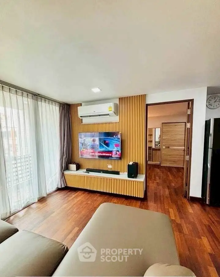 Modern living room with wooden flooring and stylish TV setup