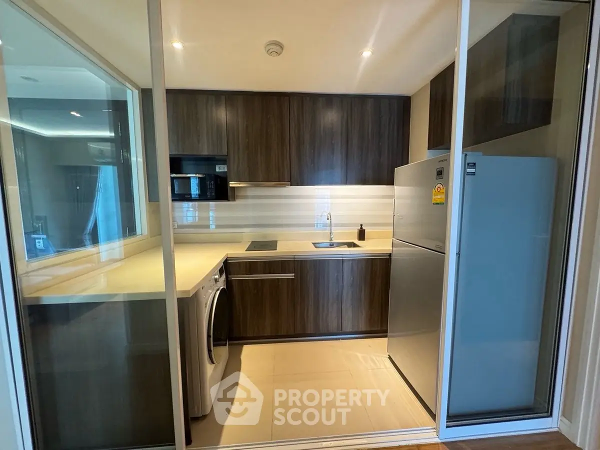 Modern kitchen with sleek cabinetry, built-in appliances, and ample counter space in a stylish apartment.