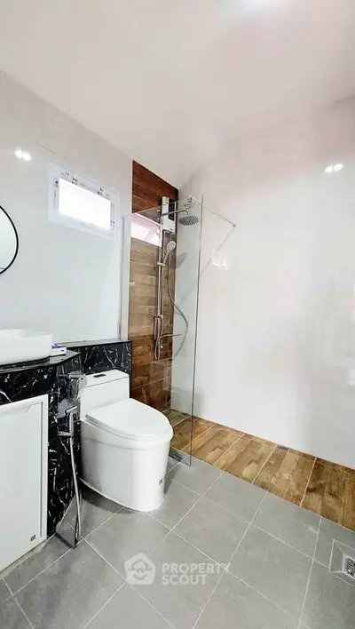 Modern bathroom with sleek design, featuring a glass shower enclosure and stylish fixtures.