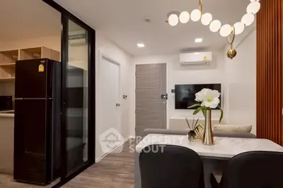 Modern living room with stylish decor and open kitchen layout, featuring sleek appliances and elegant lighting.