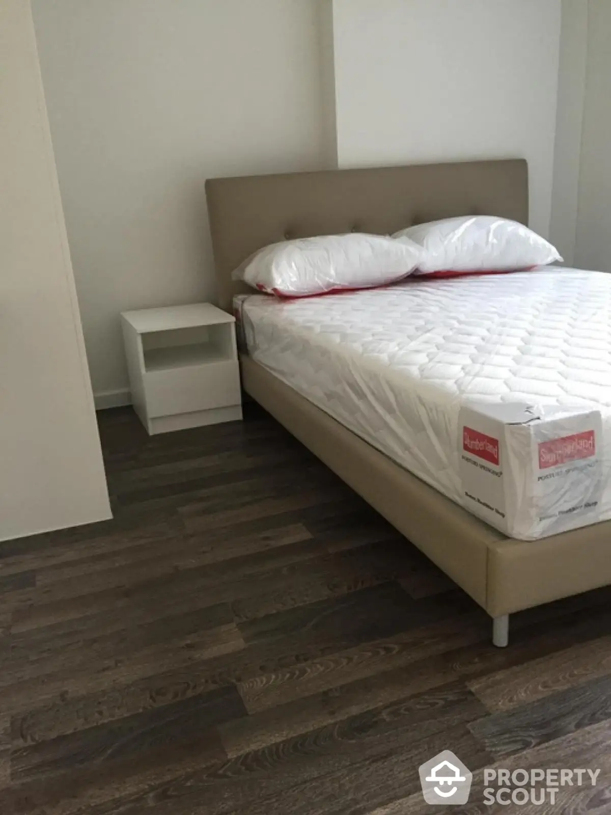 Modern bedroom with stylish bed and wooden flooring in a contemporary apartment.