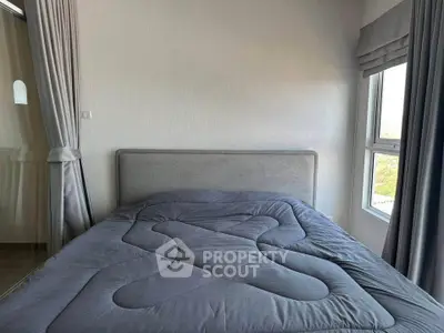 Cozy bedroom with modern gray bedding and large windows for natural light.