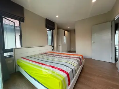 Spacious bedroom with modern decor and large windows in a stylish home.