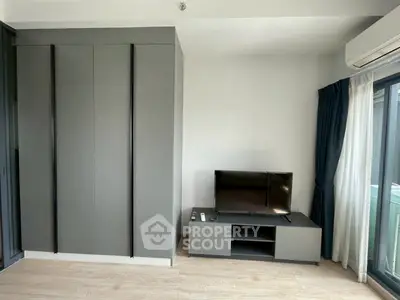 Modern living room with sleek TV stand and built-in wardrobe, featuring natural light and minimalist design.