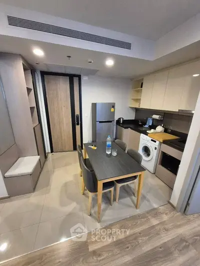 Modern kitchen with dining area, washing machine, and sleek appliances.