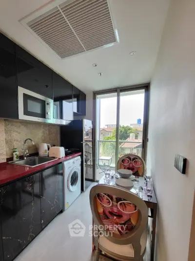 Modern kitchen with sleek black cabinets, red countertop, and balcony view