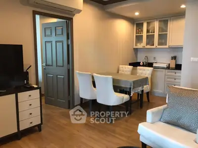 Charming open-plan living and dining area with modern kitchen in cozy apartment.