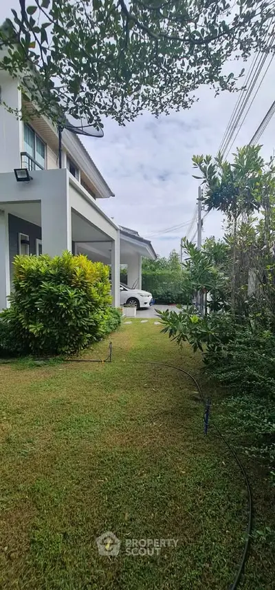 Charming suburban home with lush garden and driveway view, perfect for family living.