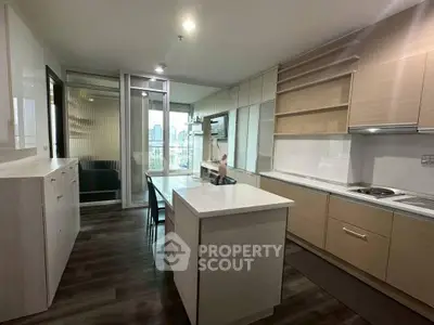 Modern kitchen with island and open layout in a high-rise apartment with city view.