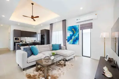 Spacious modern living room with open kitchen, featuring elegant decor and ample natural light.