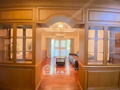 Spacious living room with elegant wooden paneling and cozy seating area.