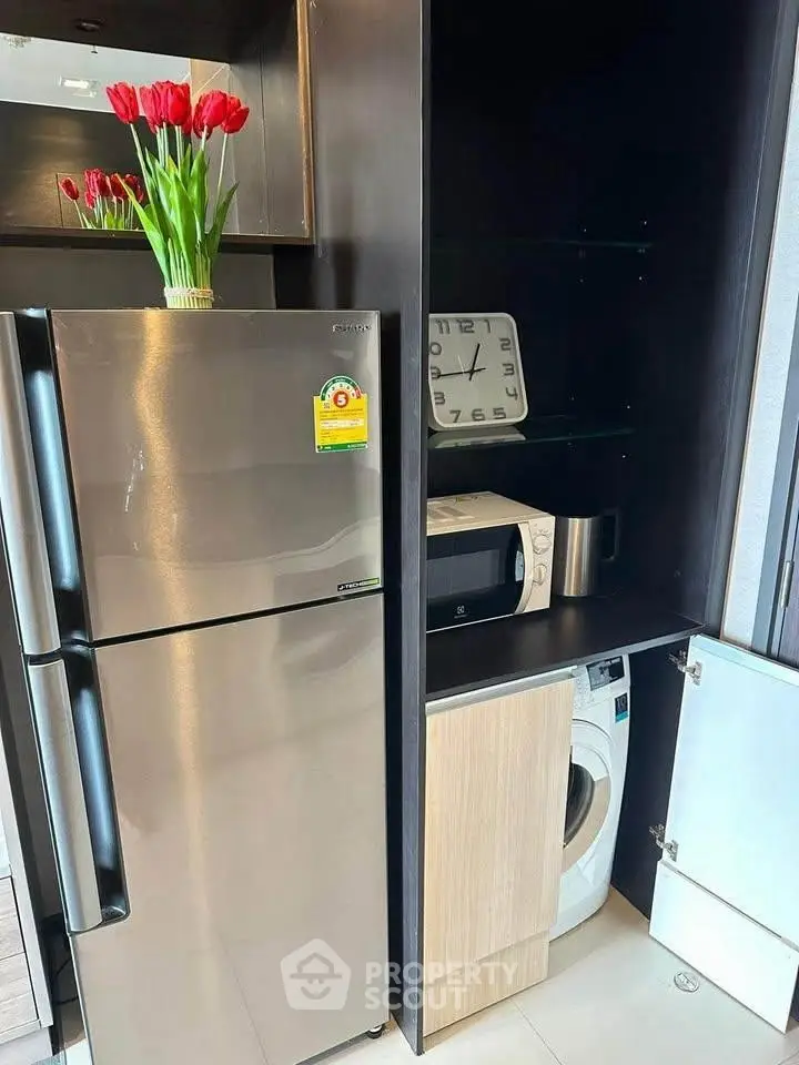 Modern kitchen with stainless steel fridge, microwave, and washing machine