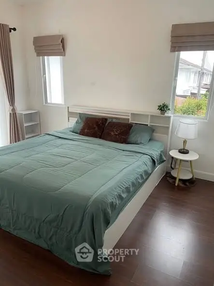 Cozy bedroom with large windows and modern decor, perfect for relaxation.