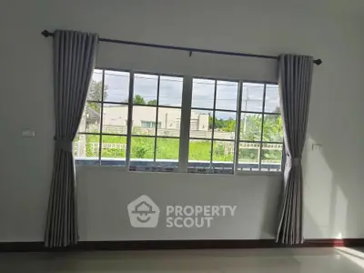 Bright room with large window offering a lush green view, perfect for natural light lovers.