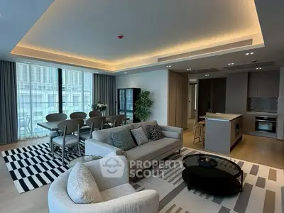 Luxurious modern living room with open kitchen and elegant dining area, featuring stylish furniture and ambient lighting.