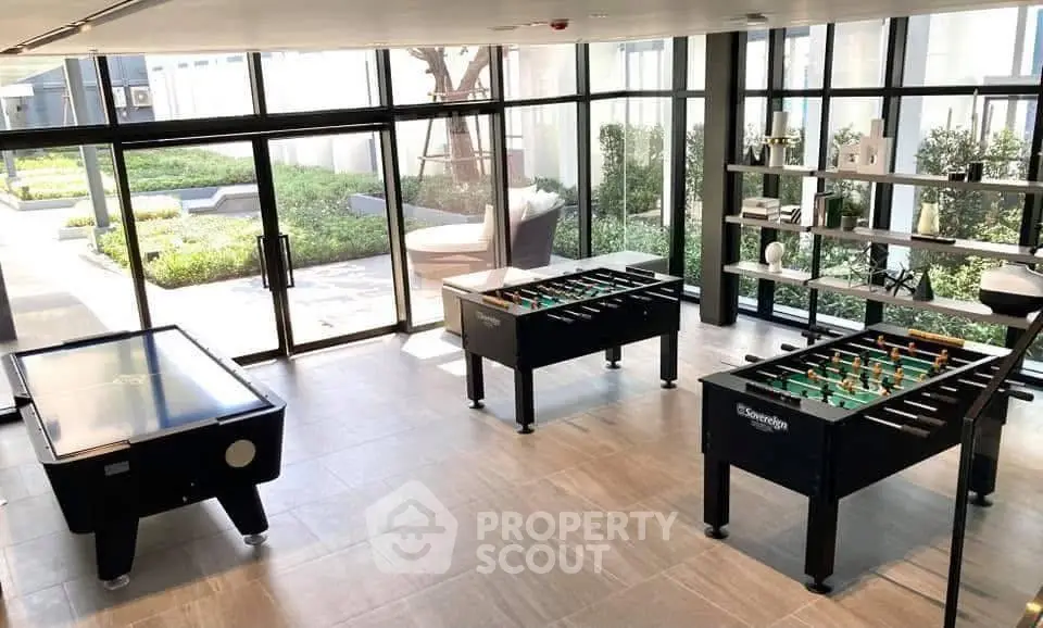 Modern recreational room with foosball and air hockey tables in a stylish apartment complex.