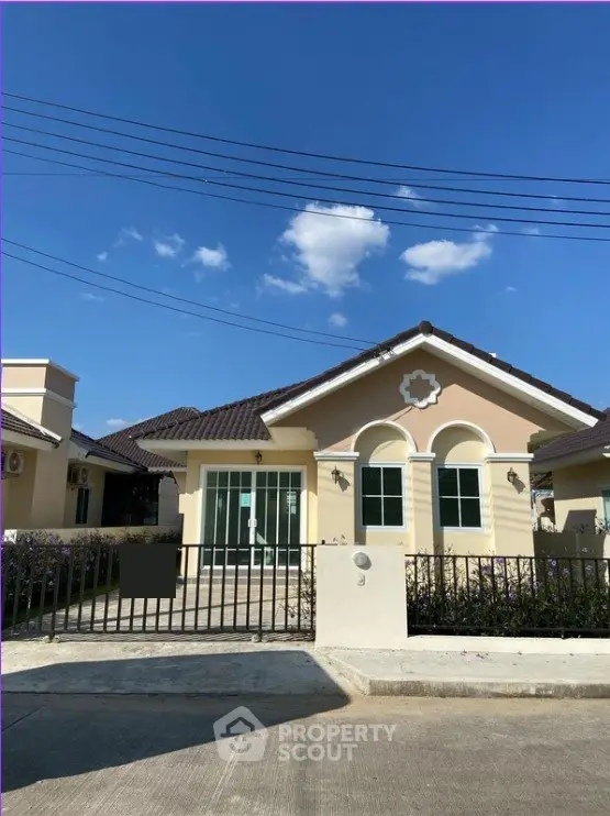 Charming single-story house with a fenced yard and clear blue sky backdrop.