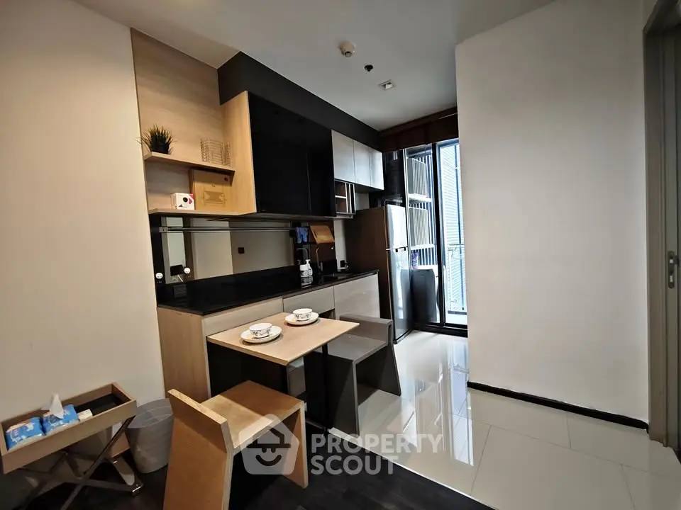 Modern compact kitchen with sleek design and dining area in a stylish apartment.