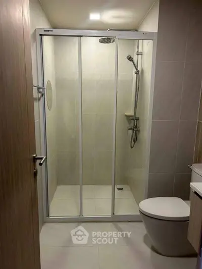 Modern bathroom with glass shower enclosure and sleek fixtures.