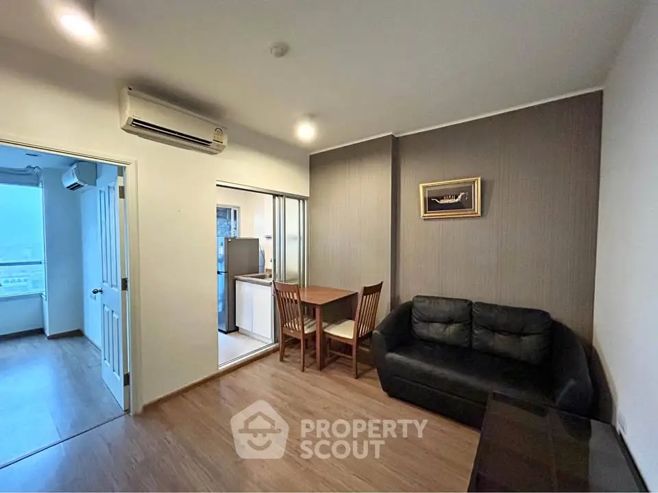 Cozy living room with modern furniture and adjacent kitchen in a stylish apartment.