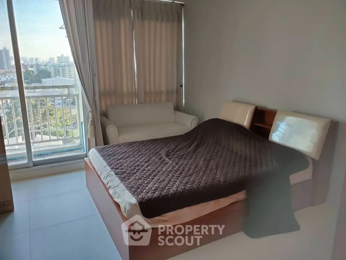 Spacious bedroom with city view and cozy seating area