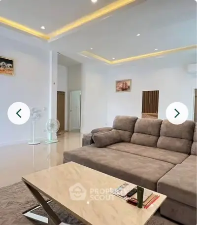 Spacious modern living room with elegant sofa and stylish coffee table, perfect for relaxation and entertainment.