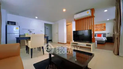 Modern open-plan living room with dining area and bedroom in stylish apartment