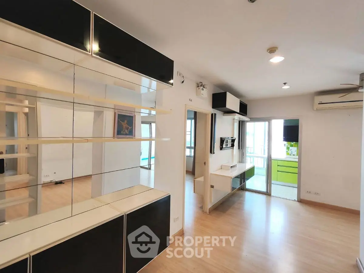 Modern open-layout living room with sleek built-in shelving and bright natural light.