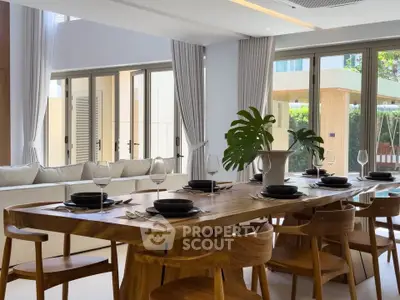 Luxurious dining area with elegant wooden table and chairs, surrounded by large windows and natural light.