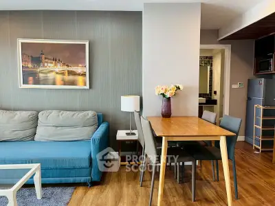Modern living room with stylish decor and dining area, featuring a cozy sofa and elegant wooden flooring.