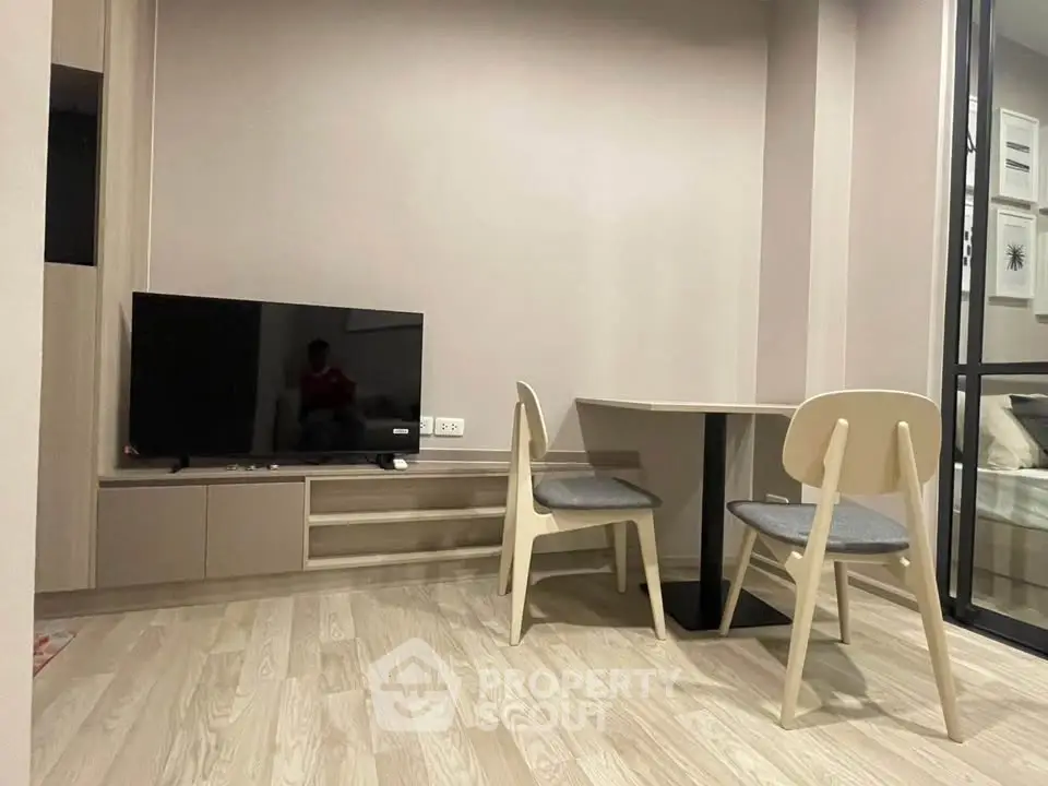 Modern living room with sleek TV setup and cozy dining area