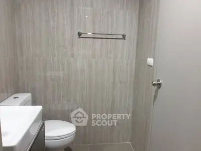 Modern minimalist bathroom with sleek fixtures and neutral tiles.