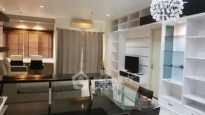 Modern living room with elegant chandelier and sleek furniture in a stylish apartment.