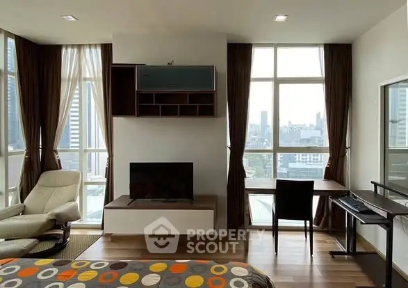 Modern living room with city view, featuring stylish furniture and large windows.
