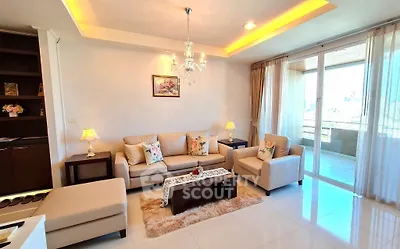 Luxurious living room with elegant chandelier and spacious balcony view
