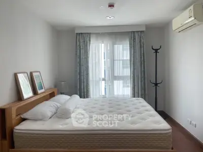 Cozy bedroom with large window and air conditioning, featuring a comfortable bed and modern decor.