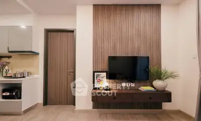 Modern living room with stylish TV setup and open kitchen layout